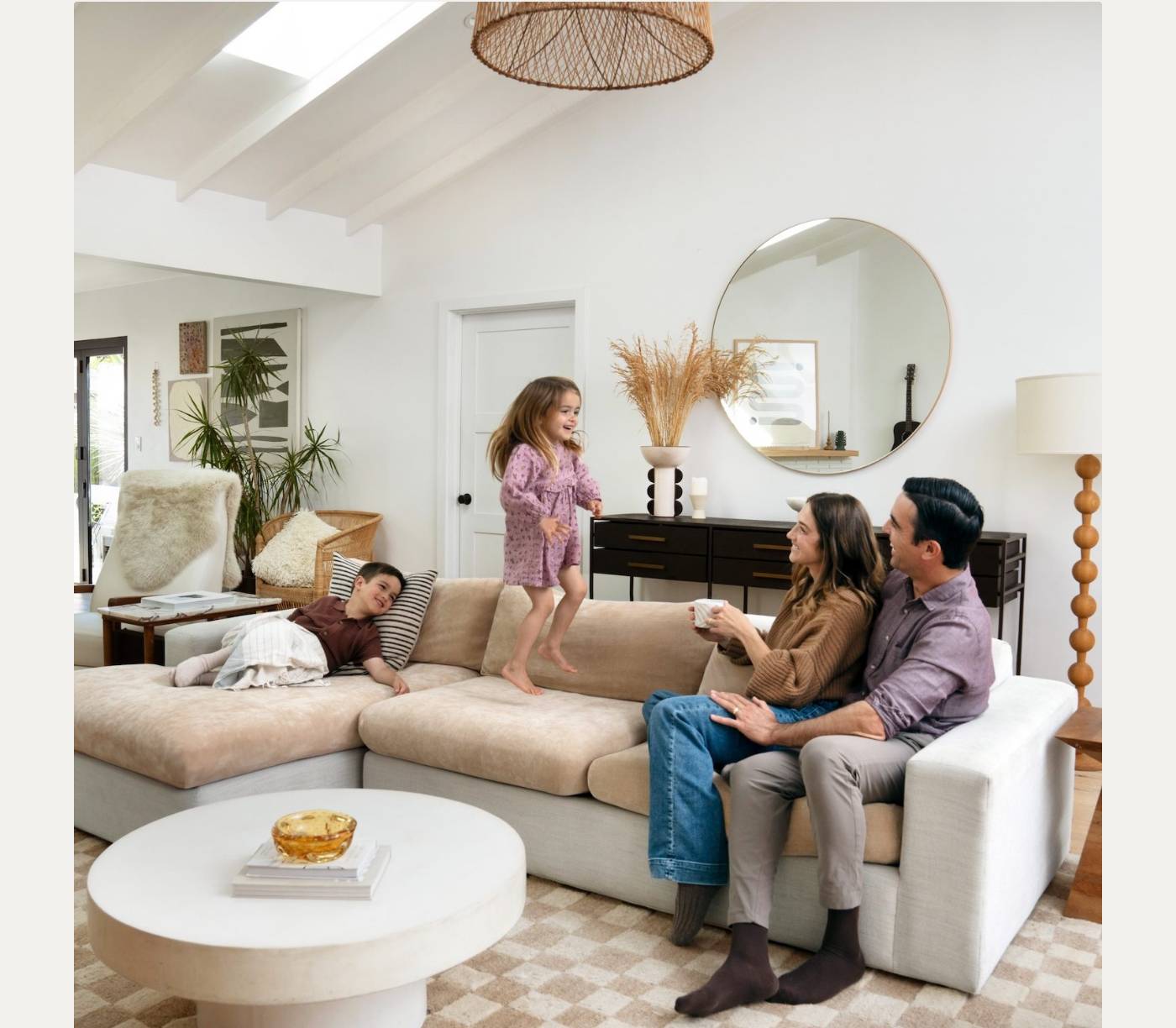 Family on a sofa with a child jumping, demonstrating a comfortable, durable living space